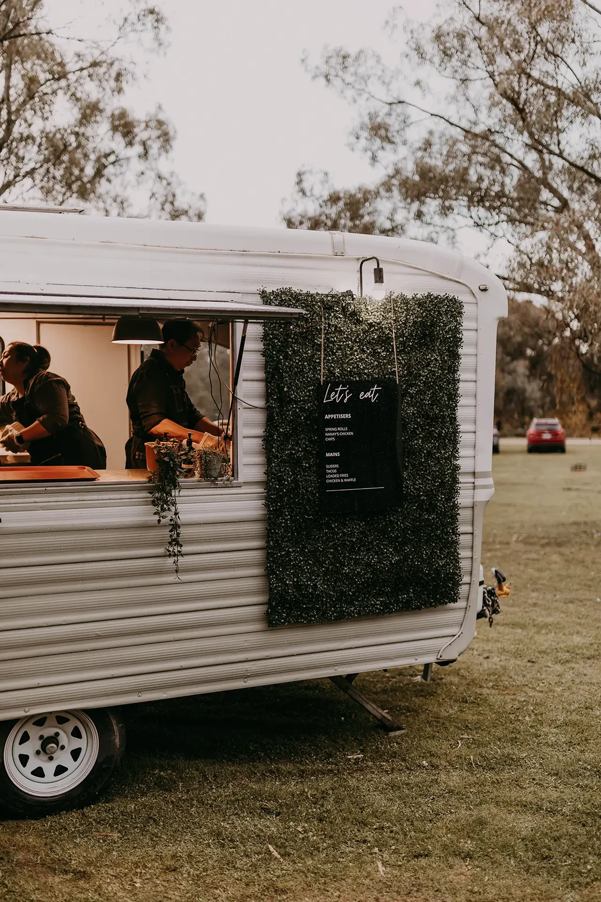 Food being prepared in a catering van among the gum trees