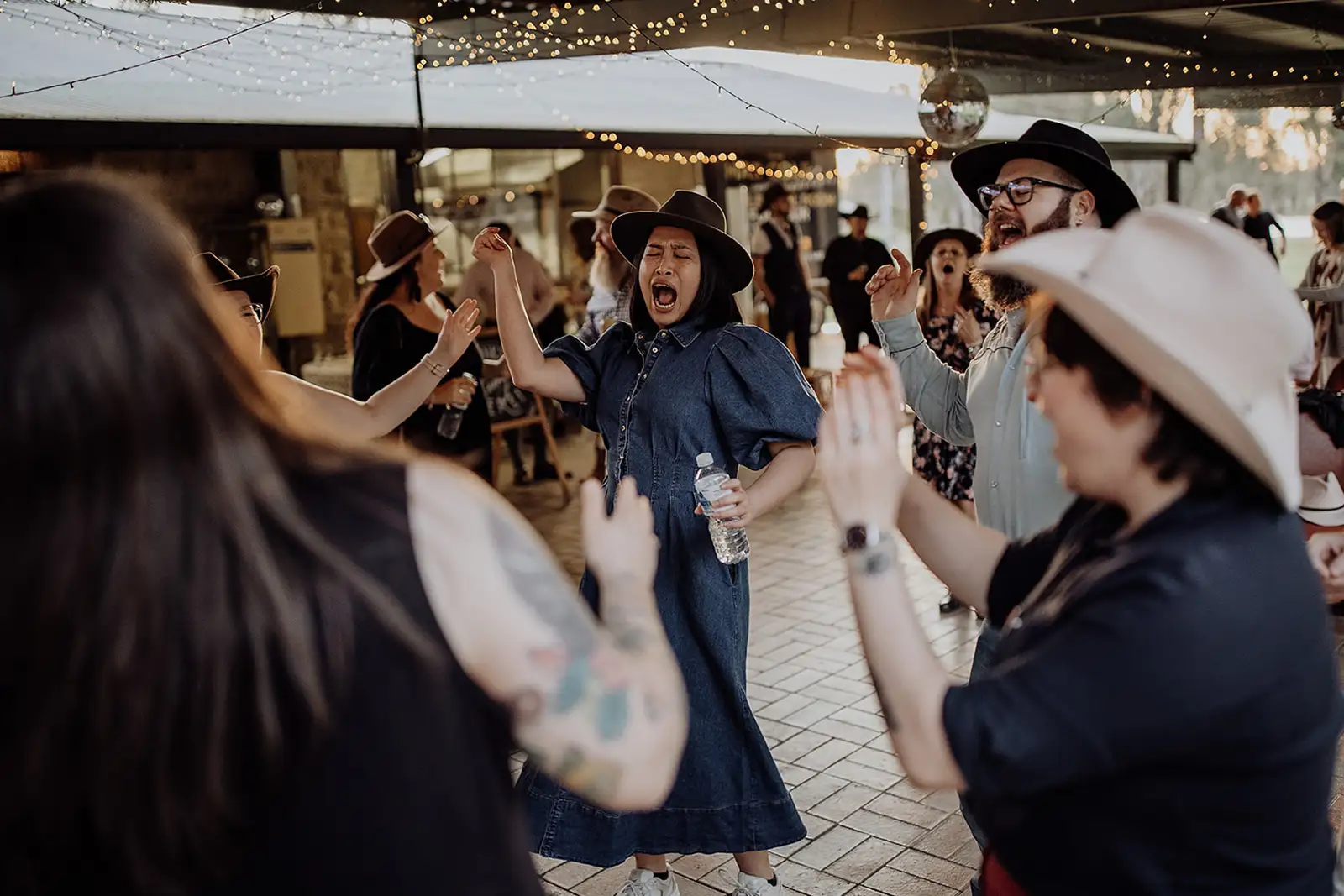 Wedding guests dancing together beneath the covered reception area
